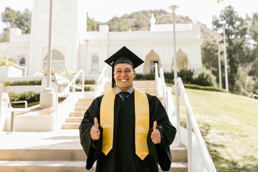 Happy graduate in cap and gown celebrating scholarship success