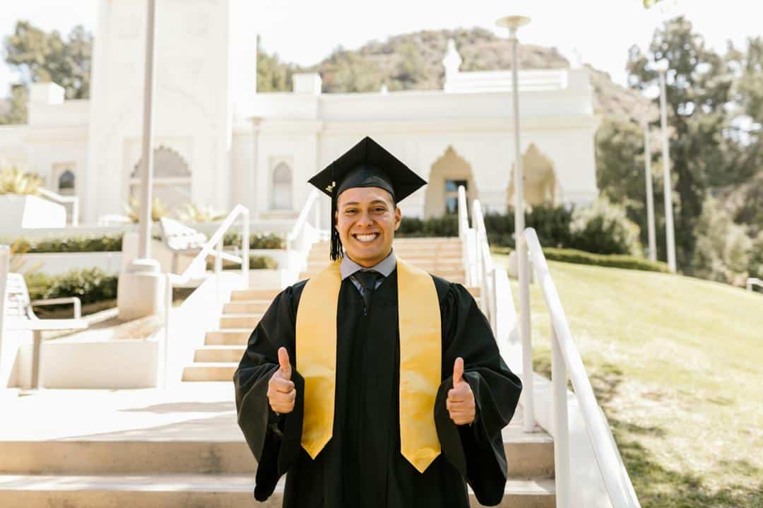 Happy graduate in cap and gown celebrating scholarship success