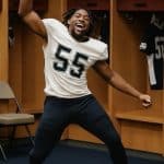 Athlete dancing in locker room with pants and dreadlocks