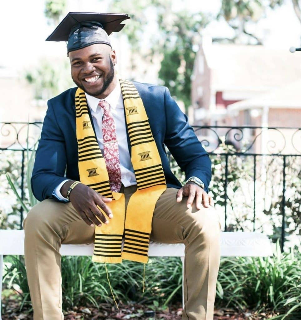 Happy graduate in cap and gown celebrating scholarship success